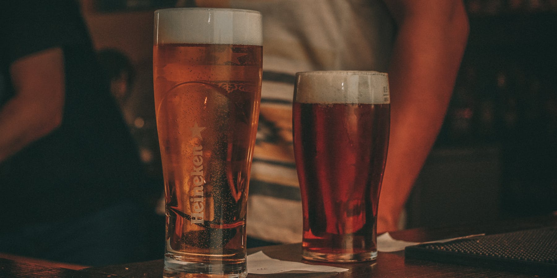 Dois copos de cerveja artesanal no balcão do bar