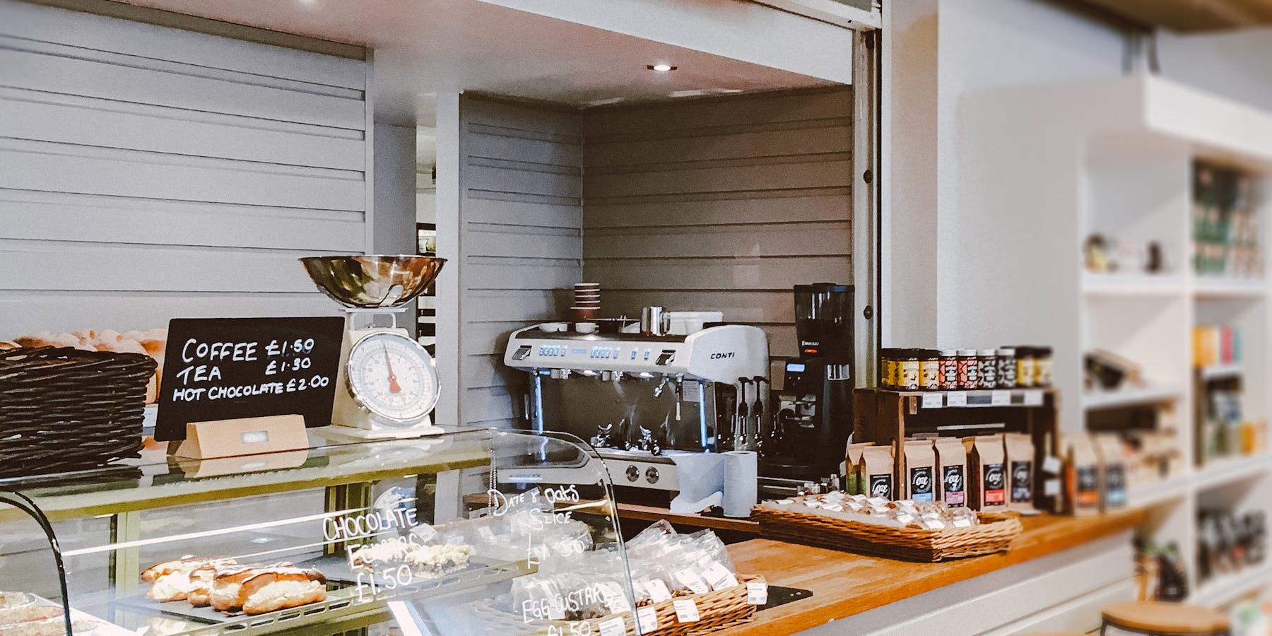 Café acolhedor com pastelaria no balcão e máquina de café