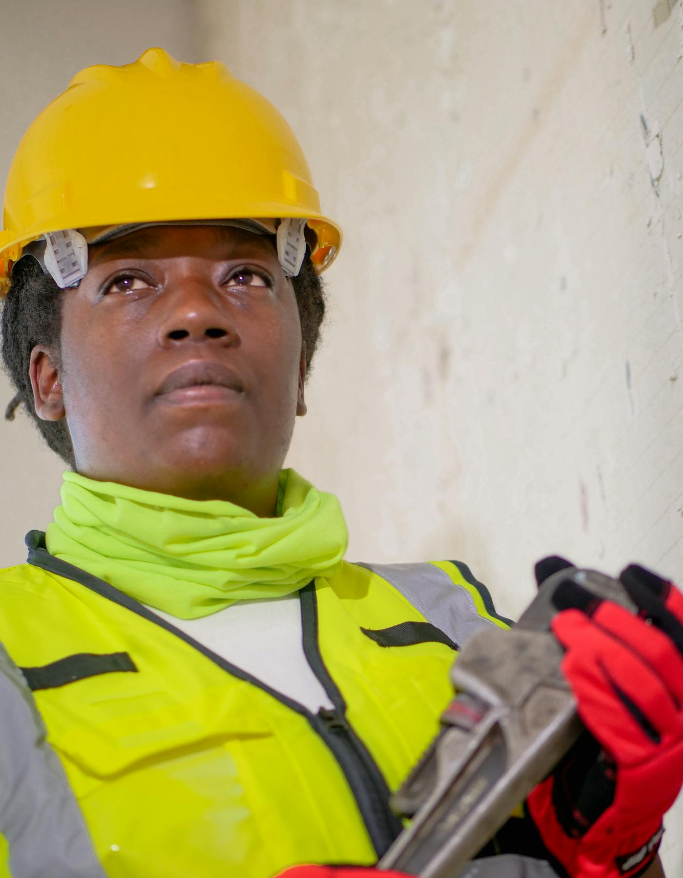 Técnica com equipamento de proteção e chave inglesa pronta para serviço
