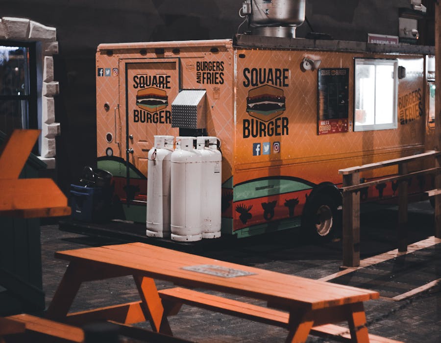 Food truck noturno com mesas na rua