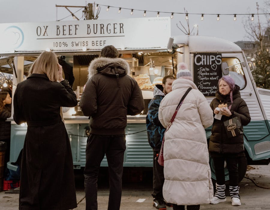 Pessoas à frente de food truck na rua