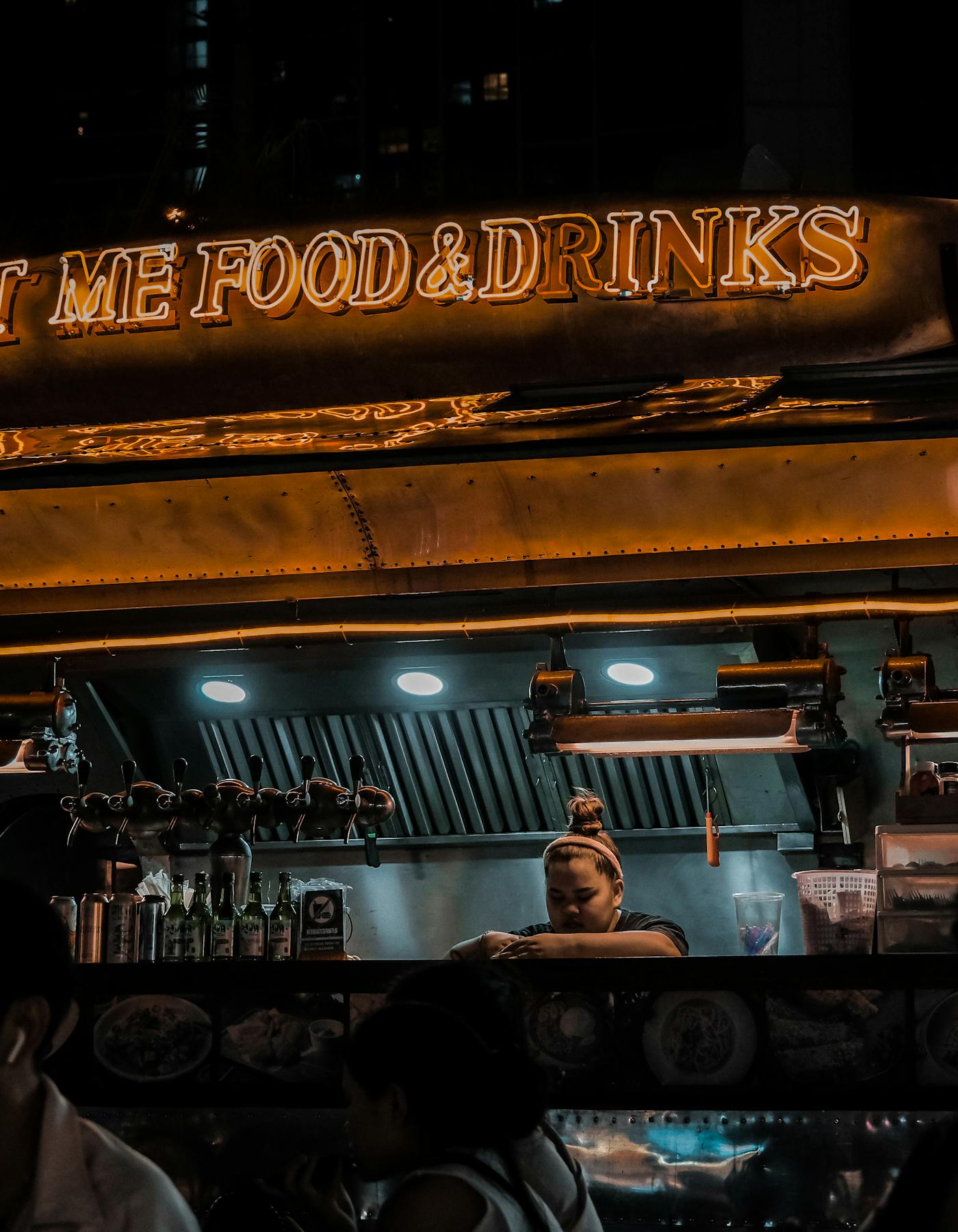 Grupo de pessoas em frente a um food truck iluminado à noite