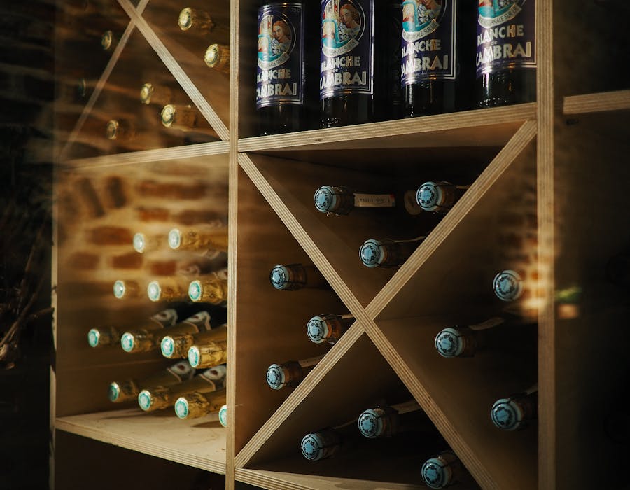 Adega com garrafas de vinho organizadas em prateleiras de madeira
