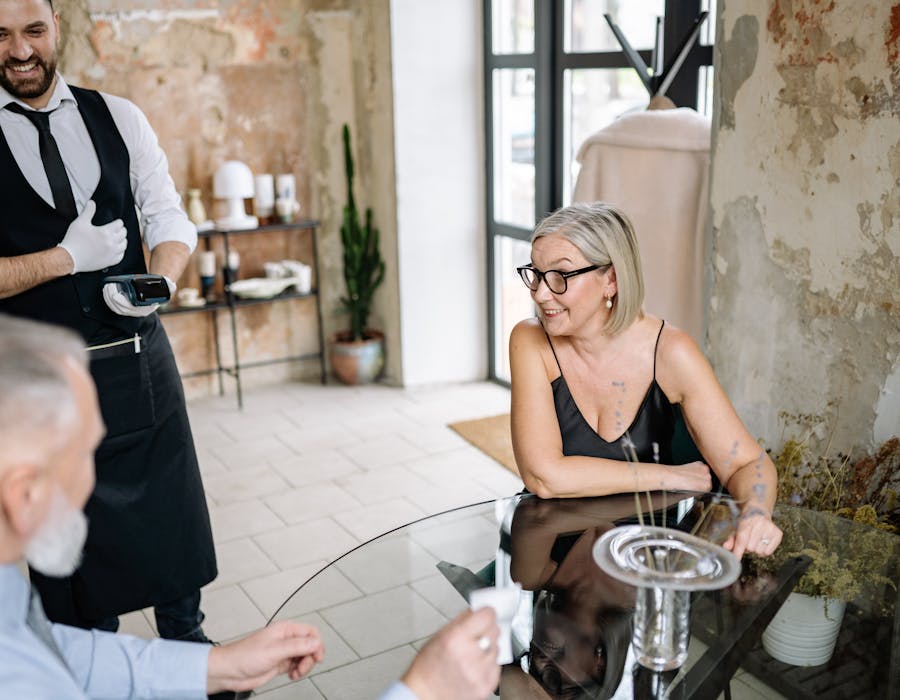 Empregado a apresentar terminal de pagamento em restaurante elegante