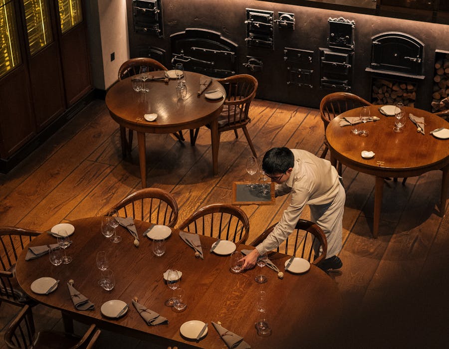 Interior acolhedor de restaurante com equipa de sala e cozinha